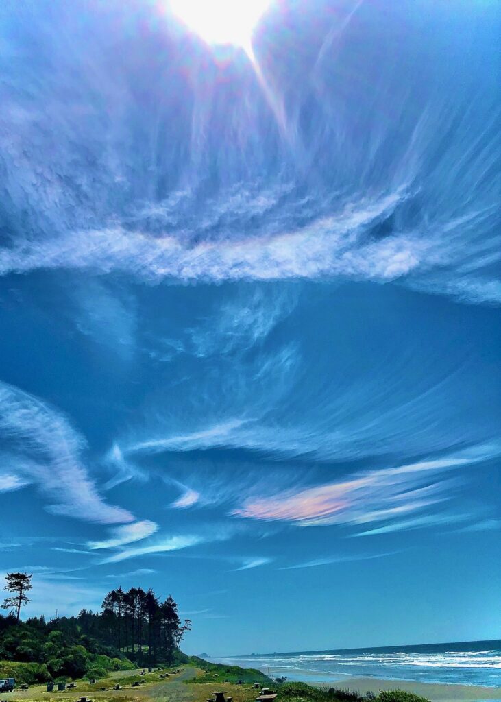 Ocean beach scene with iridescent clouds.