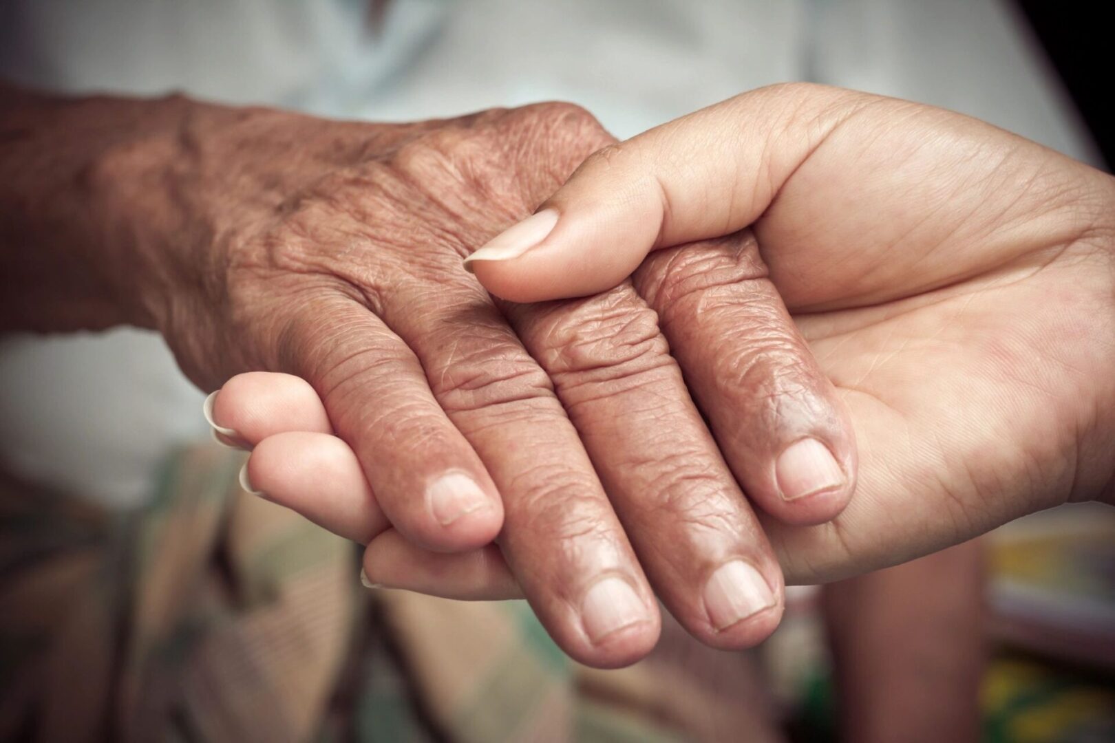 Young hand holding elderly hand.