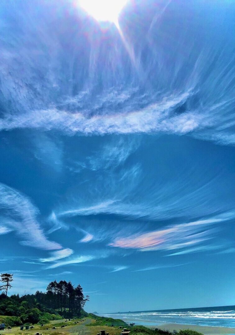 Ocean beach scene with iridescent clouds.